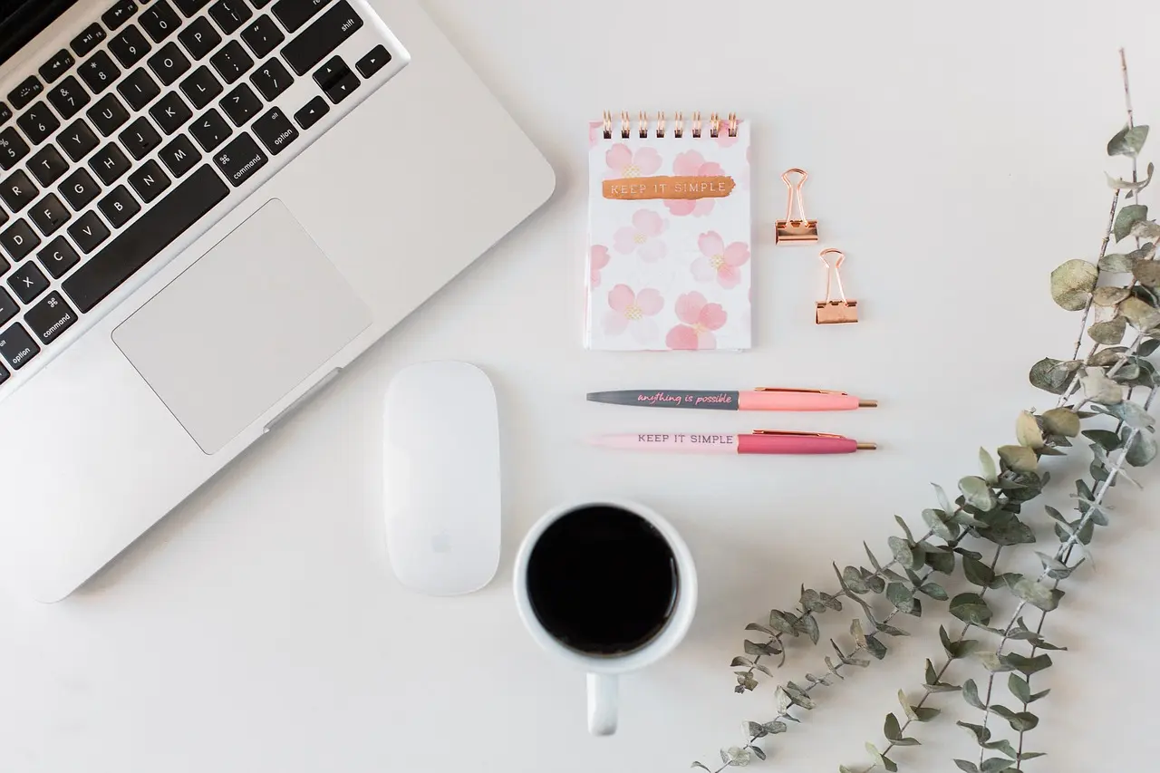 Laptop and planning materials arranged in a bright creative workspace.